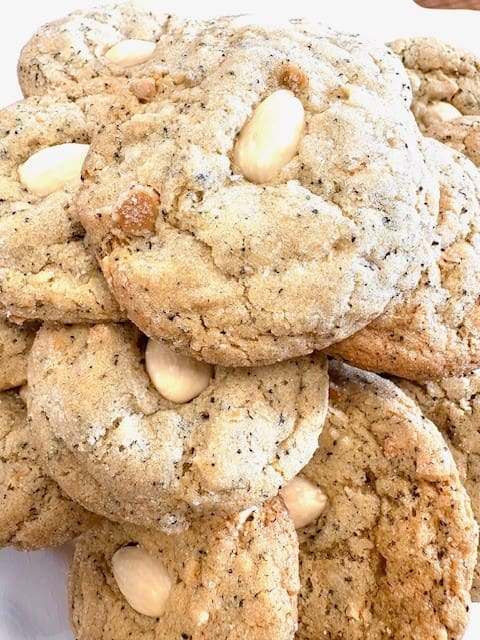Pile of almond cookies with whole almonds pressed in the center, stacked together.