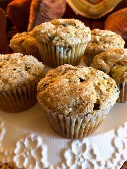Five crumb-topped muffins arranged on a white plate, fresh from the oven (home-baked)